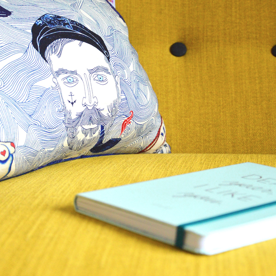 portfolio-06.jpg Book and a pillow on a yellow couch